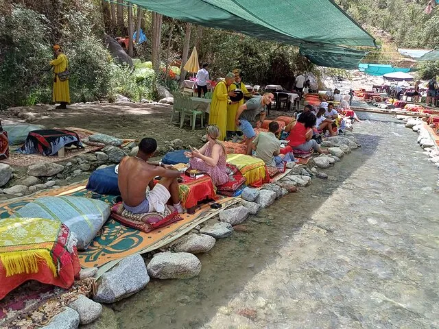 People Relaxing on Mats Along the River in Ourika Valley
