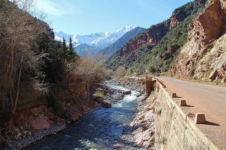 Randonneur descendant un sentier rocheux près des cascades de l'Ourika